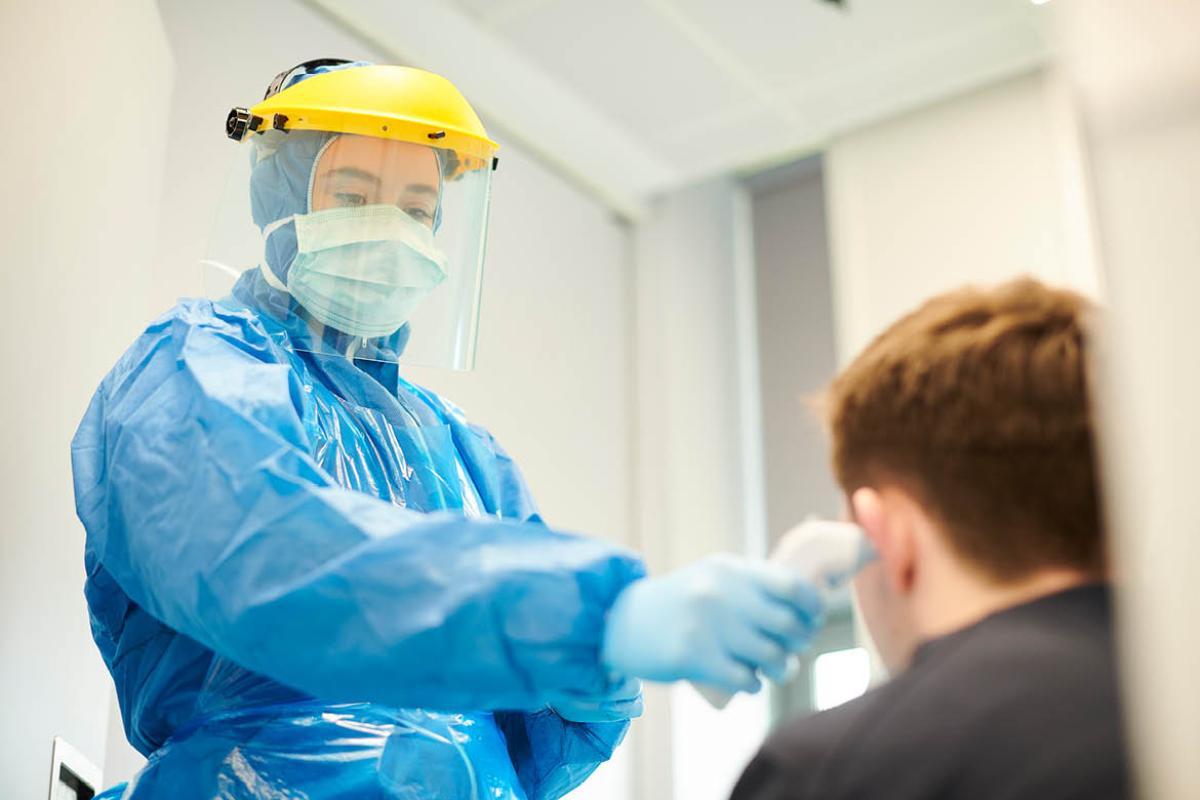 Health care worker taking patient's temperature