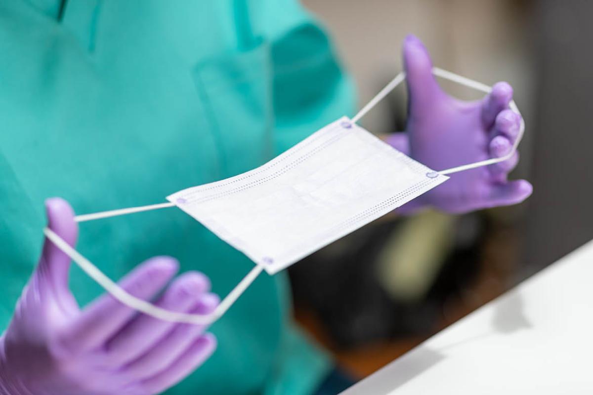 Health care worker holding face mask