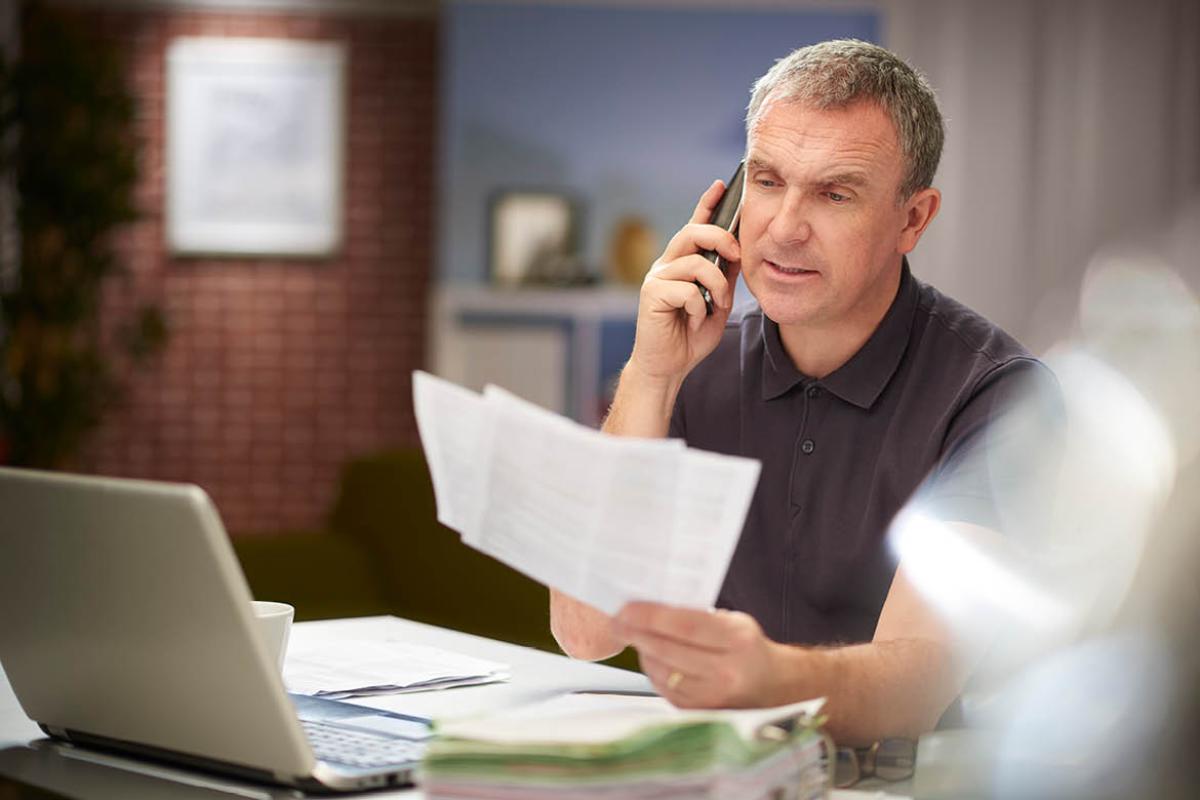 Man on phone looking at papers