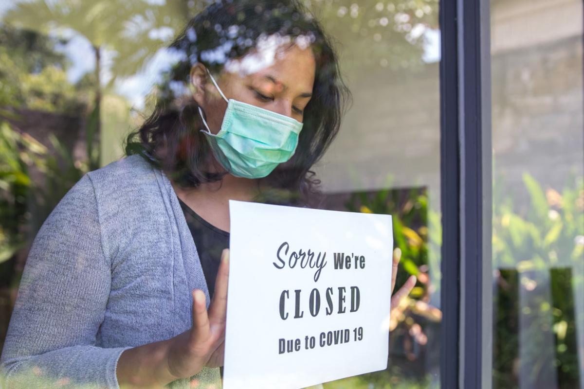 Woman holding sign in window