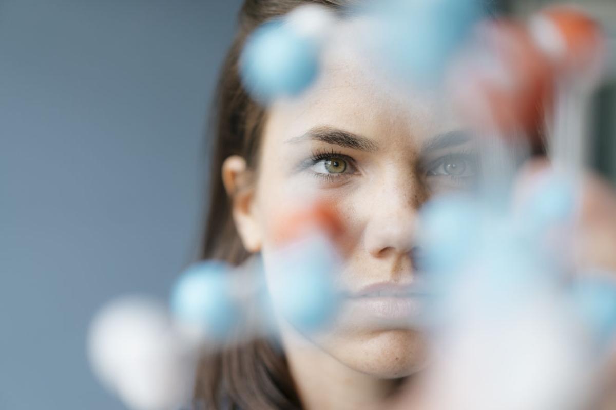 Woman behind blurry DNA strand