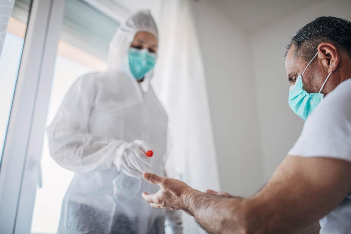 Health care worker in PPE with patient