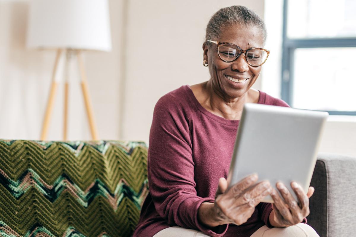 Smiling person reading tablet