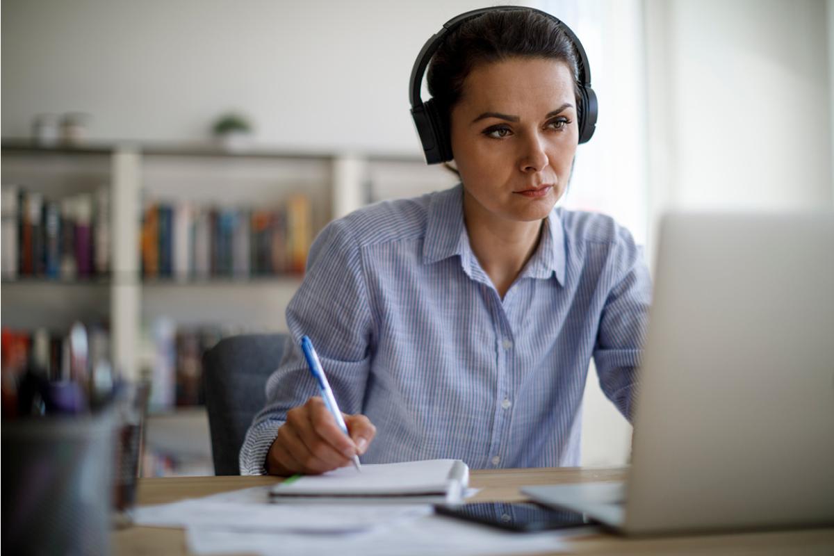 Person wearing headphones at a laptop