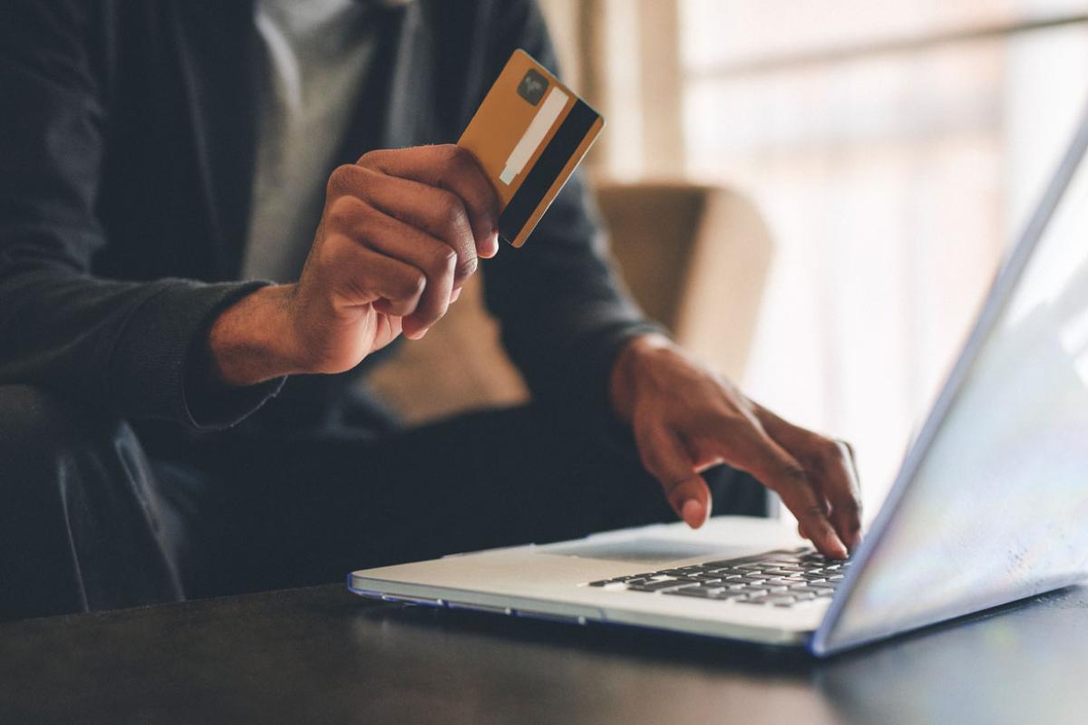 Person using their credit card at a laptop