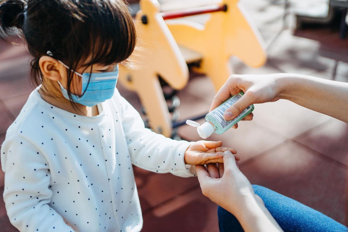 Young child applying hand sanitizer