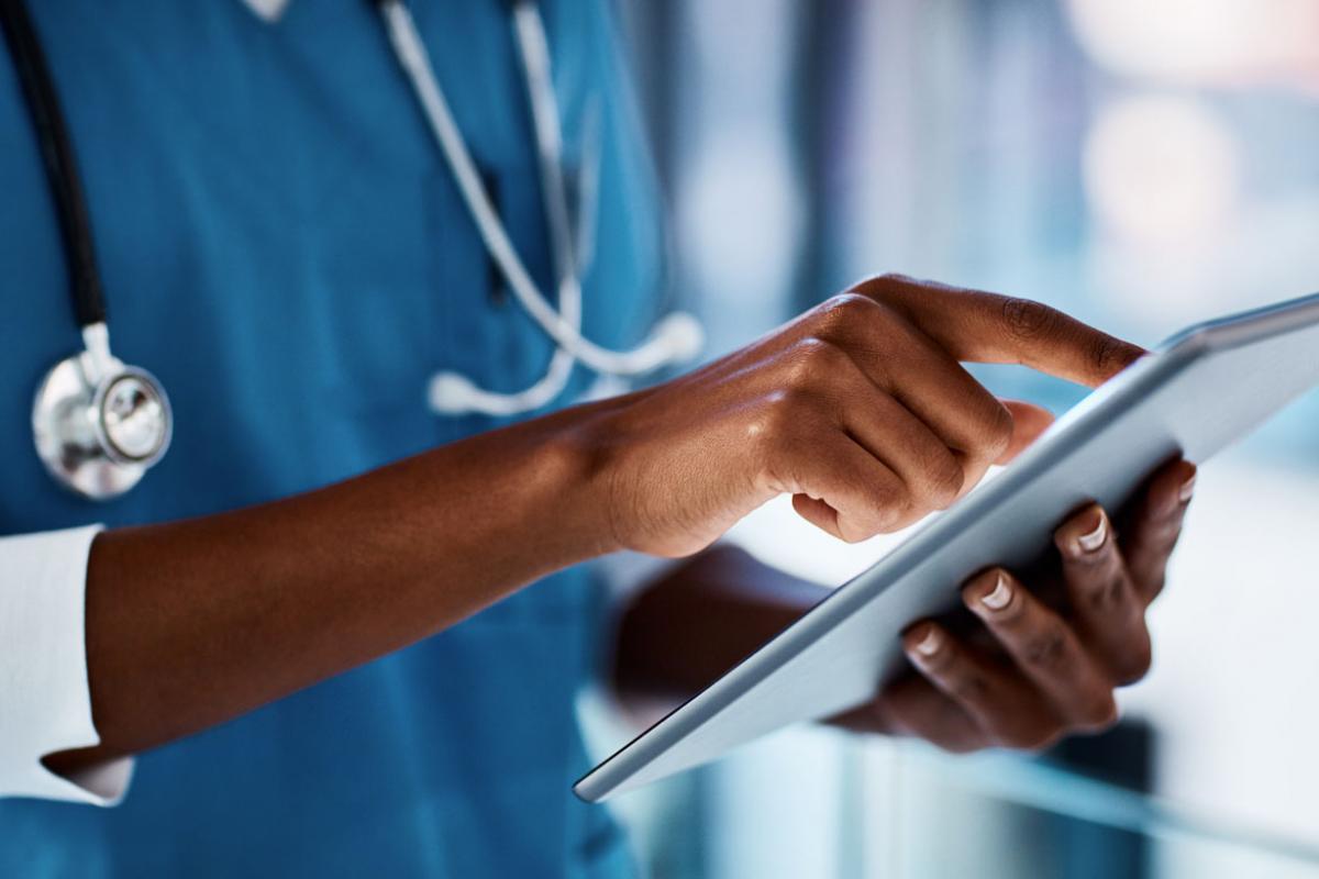 Close-up of a physician consulting a smartpad