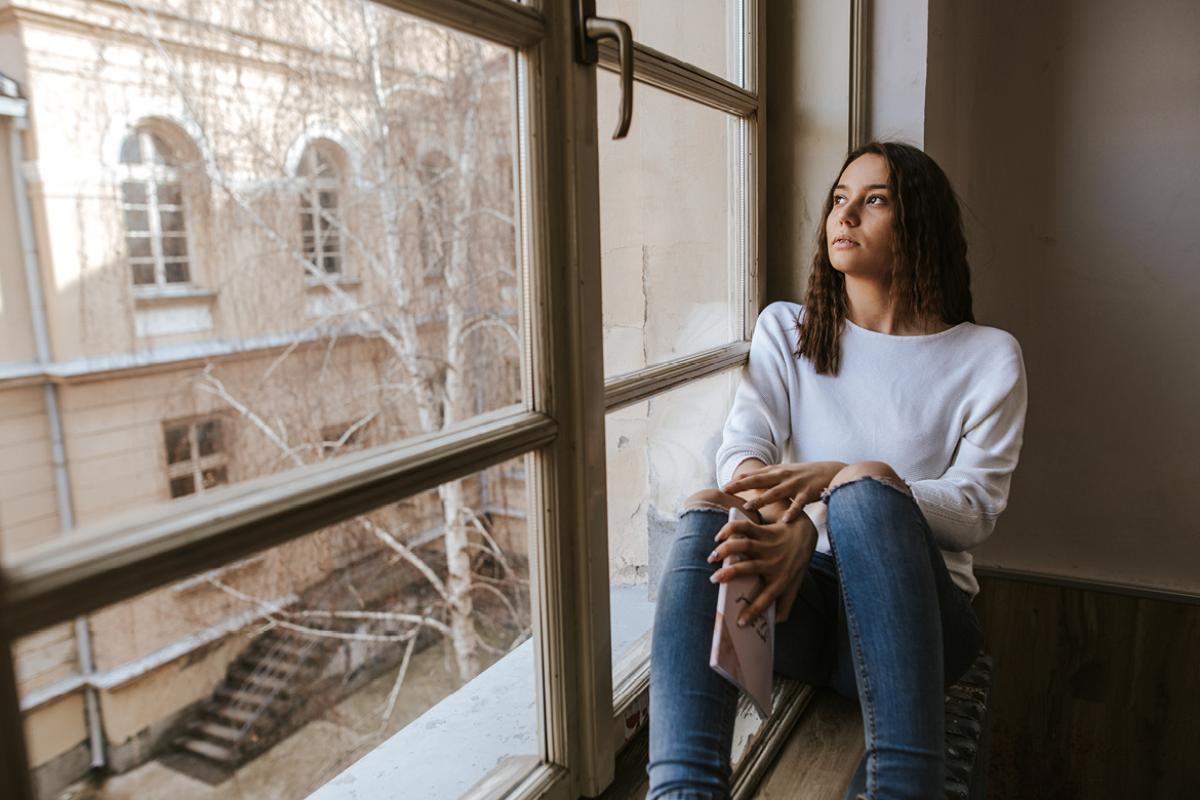 Med student sitting in the window bay of her dorm room.
