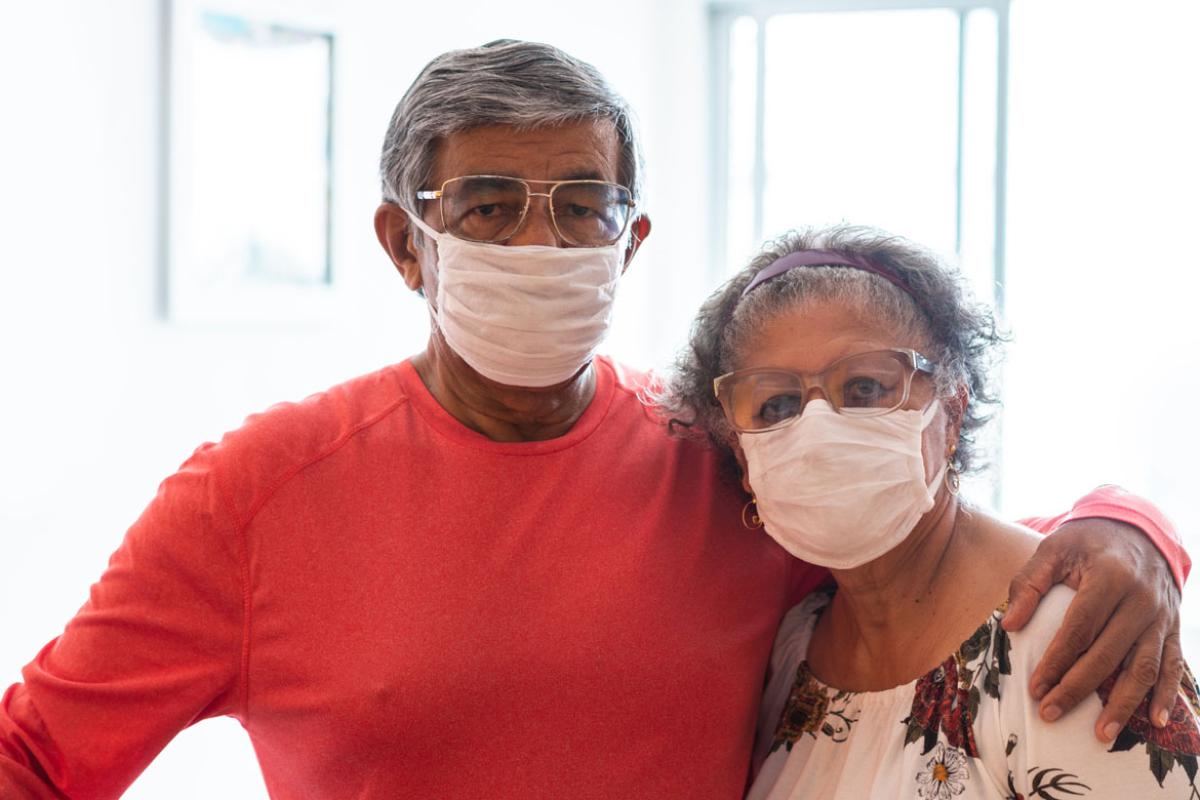 A Latinx man and woman wearing masks.