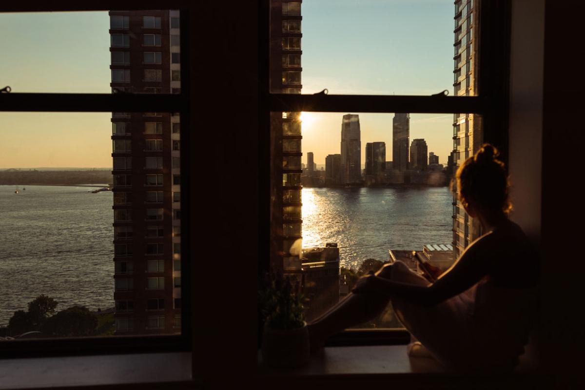Person looking out window to a cityscape