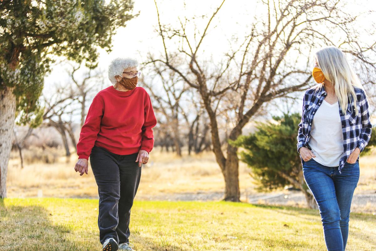 Two people wearing face masks taking a walk