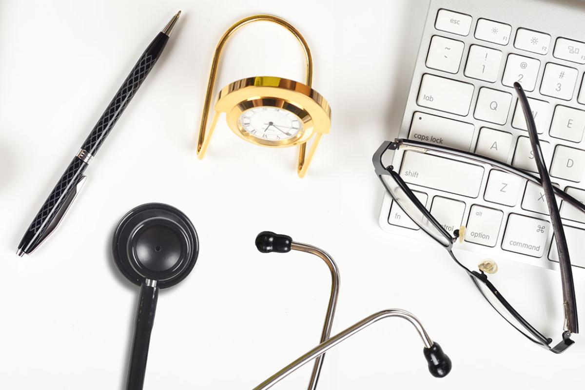 Keyboard, glasses and stethoscope on a desk