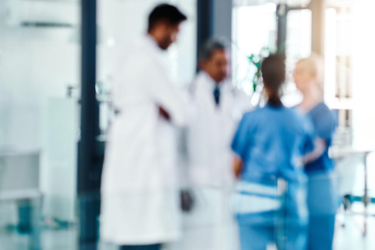 Out of focus photo for four doctors consulting each other.