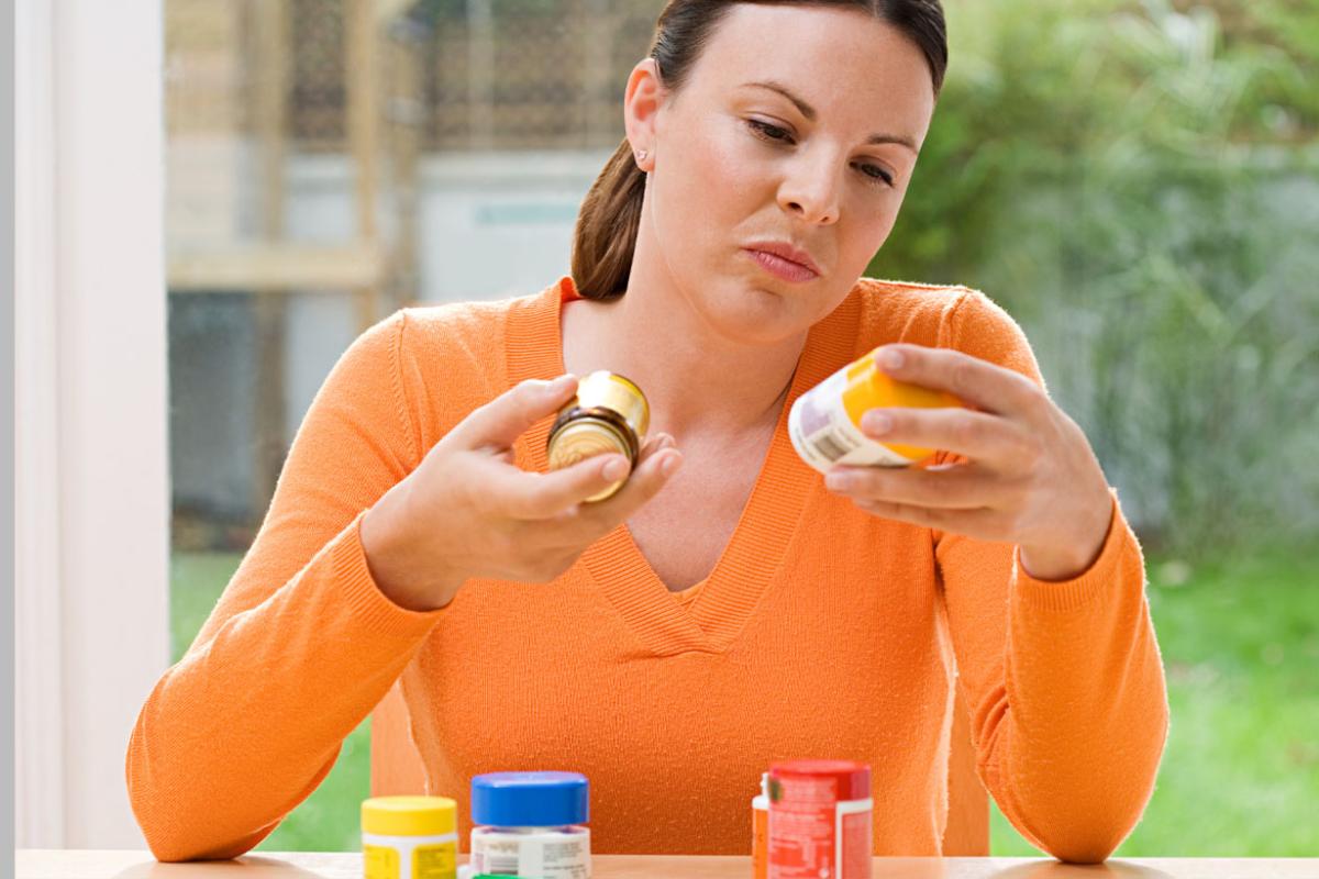 Woman choosing between supplements