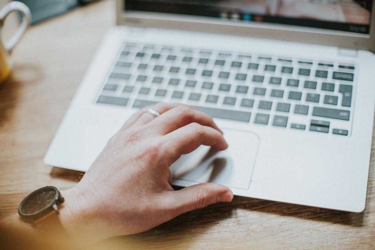 Hand typing on blurred out laptop keyboard