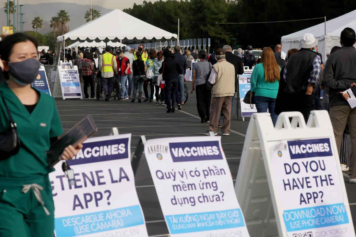 People wait in line to receive the COVID-19 vaccine at a mass vaccination site
