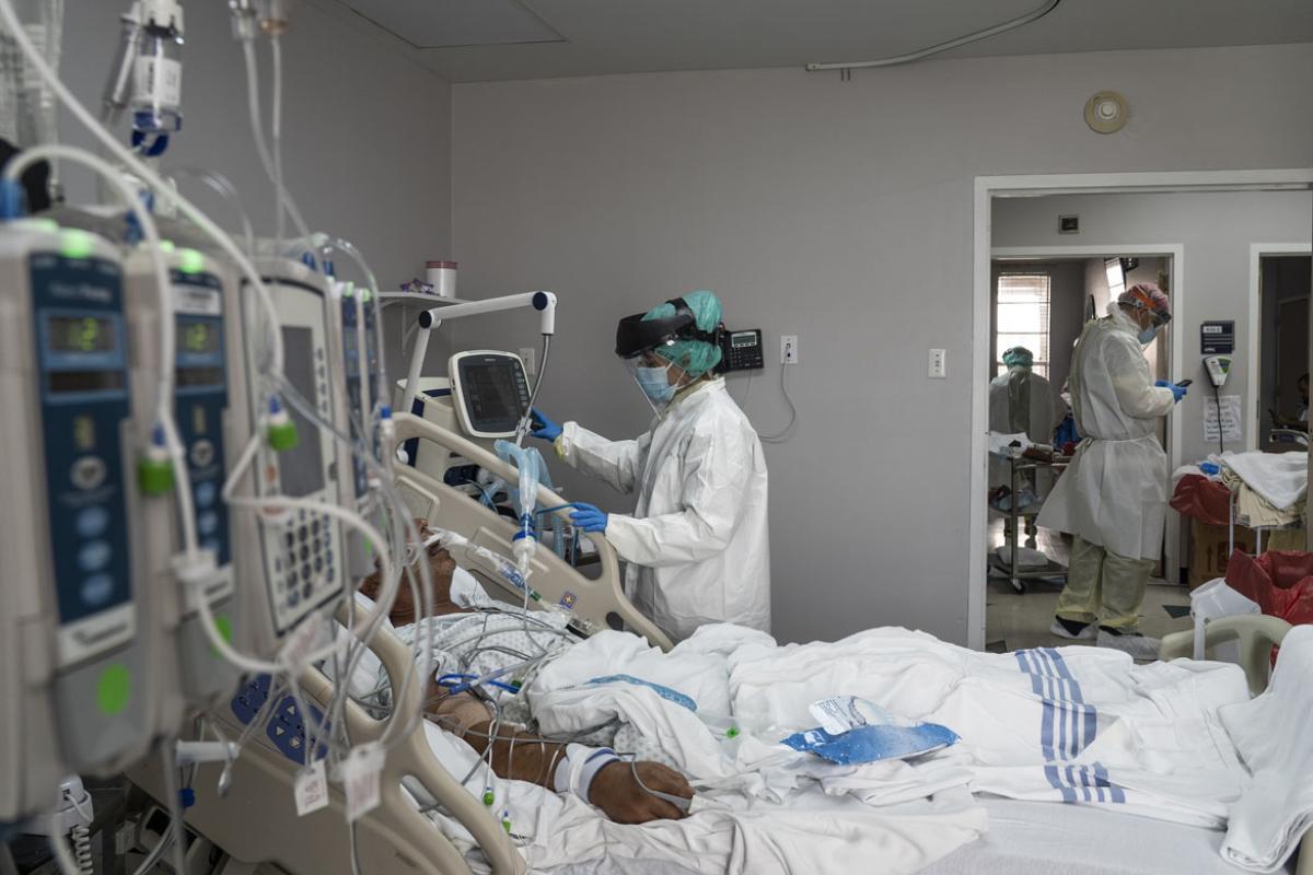 A member of the medical staff wearing full PPE treats a patient in the Covid-19 intensive care unit