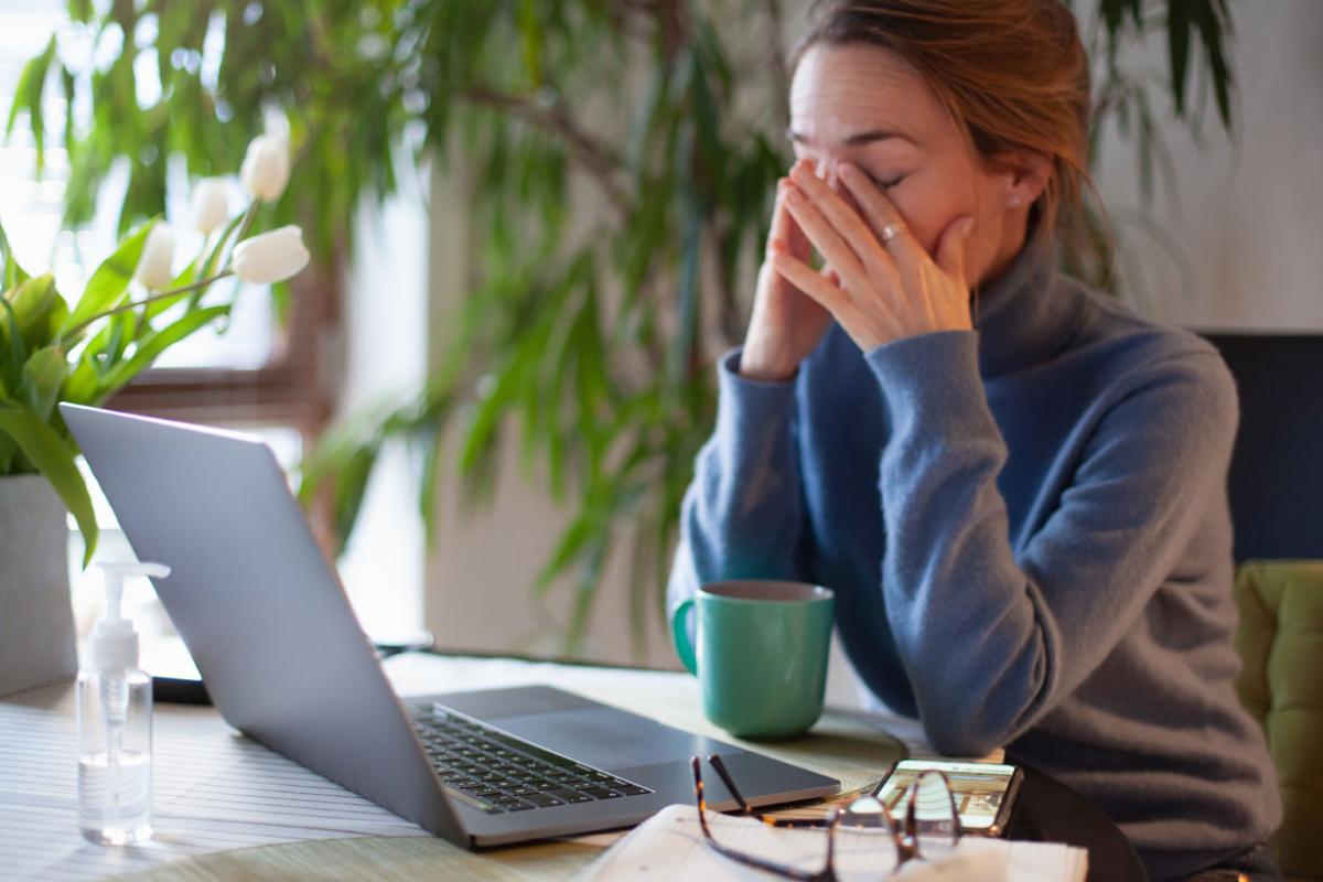 A fatigued woman sitting at her desk
