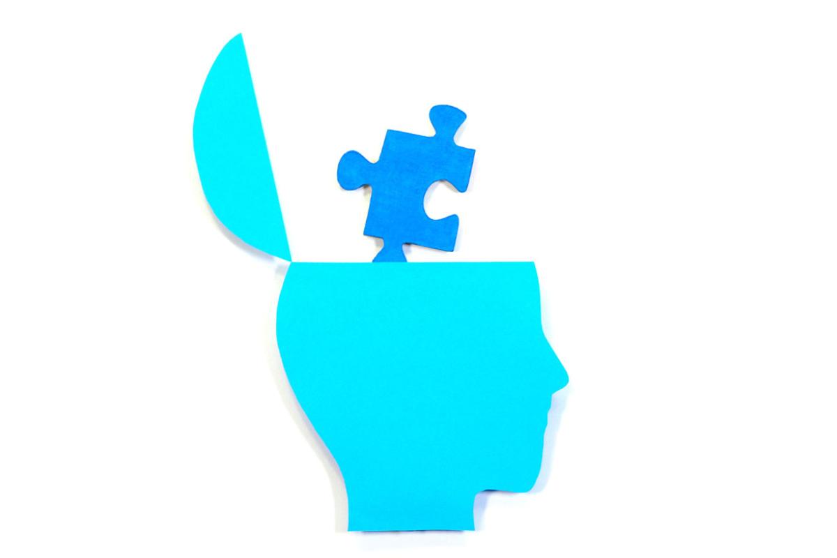 Puzzle piece coming out of human brain.