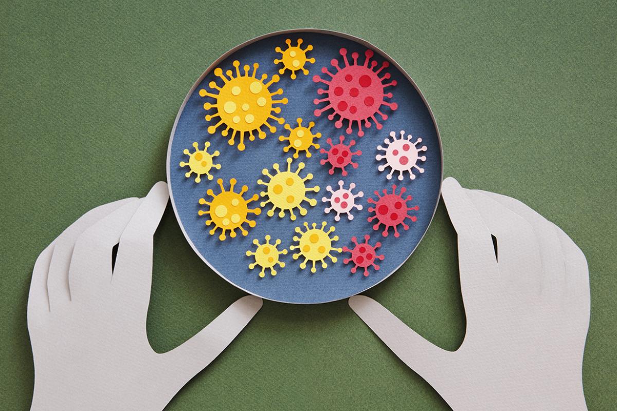Conceptual paper illustration of human hands and coronavirus in a lab