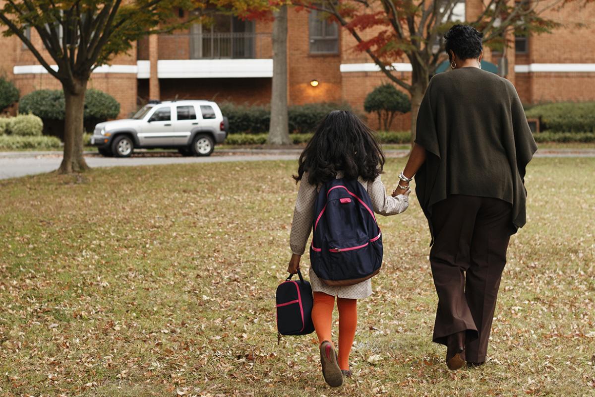 Parent and child holding hands and walking
