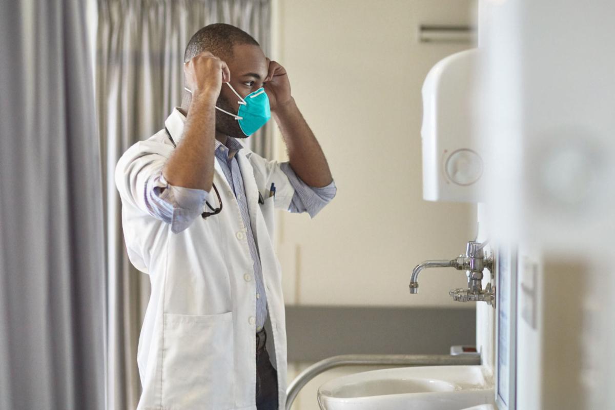 Physician putting on a mask