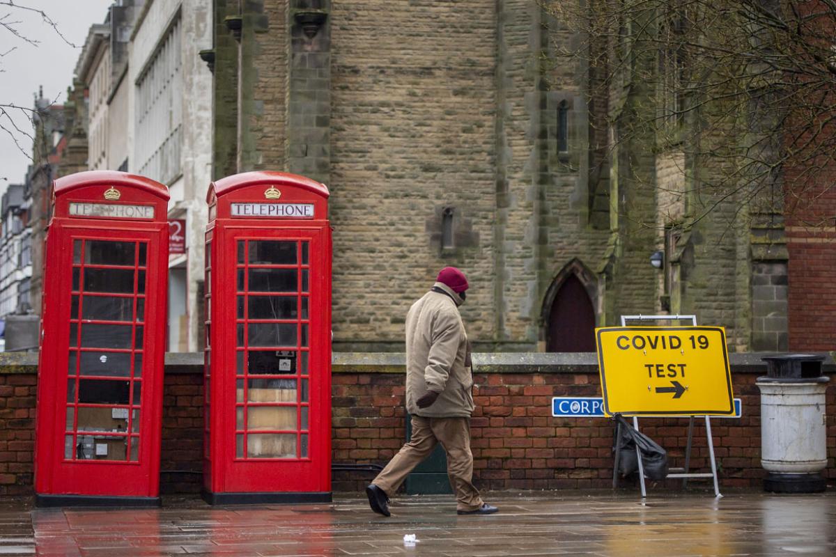 Person walking by a COVID-19 testing sign
