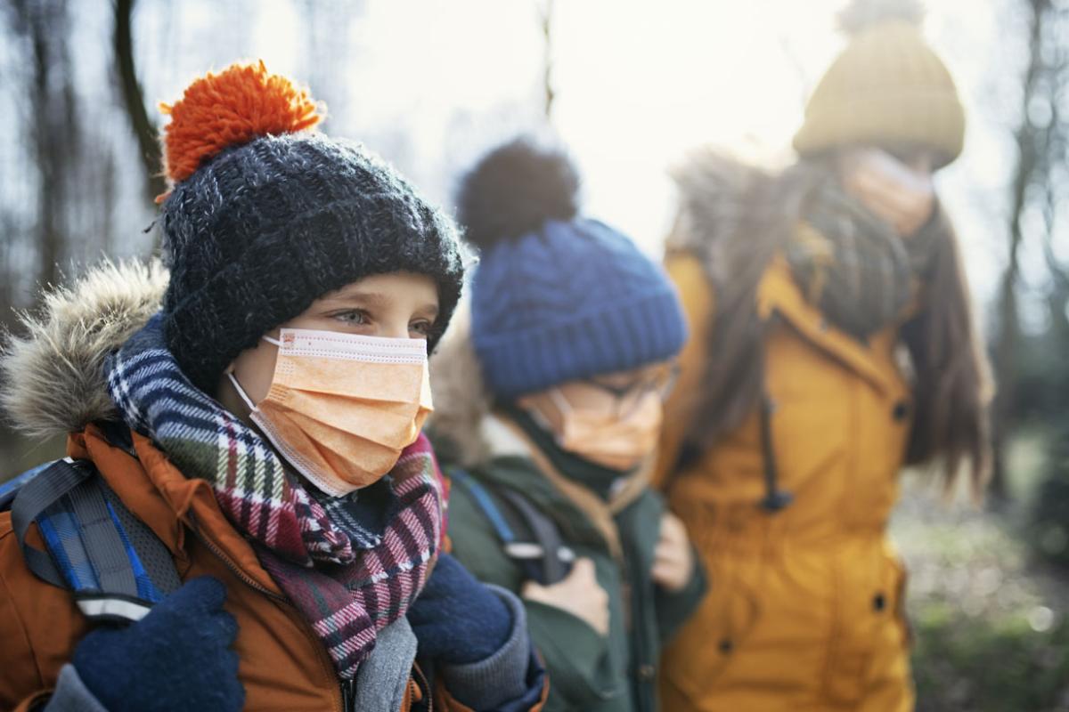 Three people wearing face masks and walking outdoors
