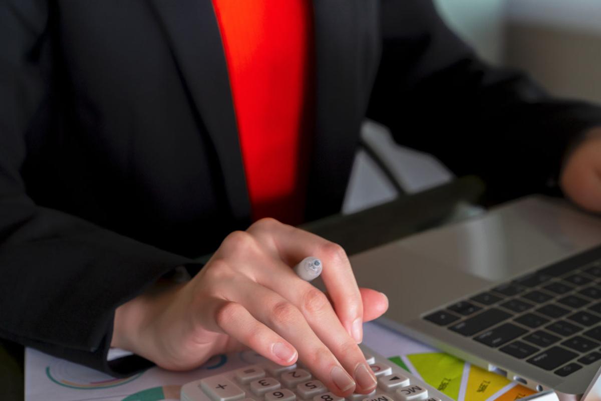 Hand on a calculator and laptop