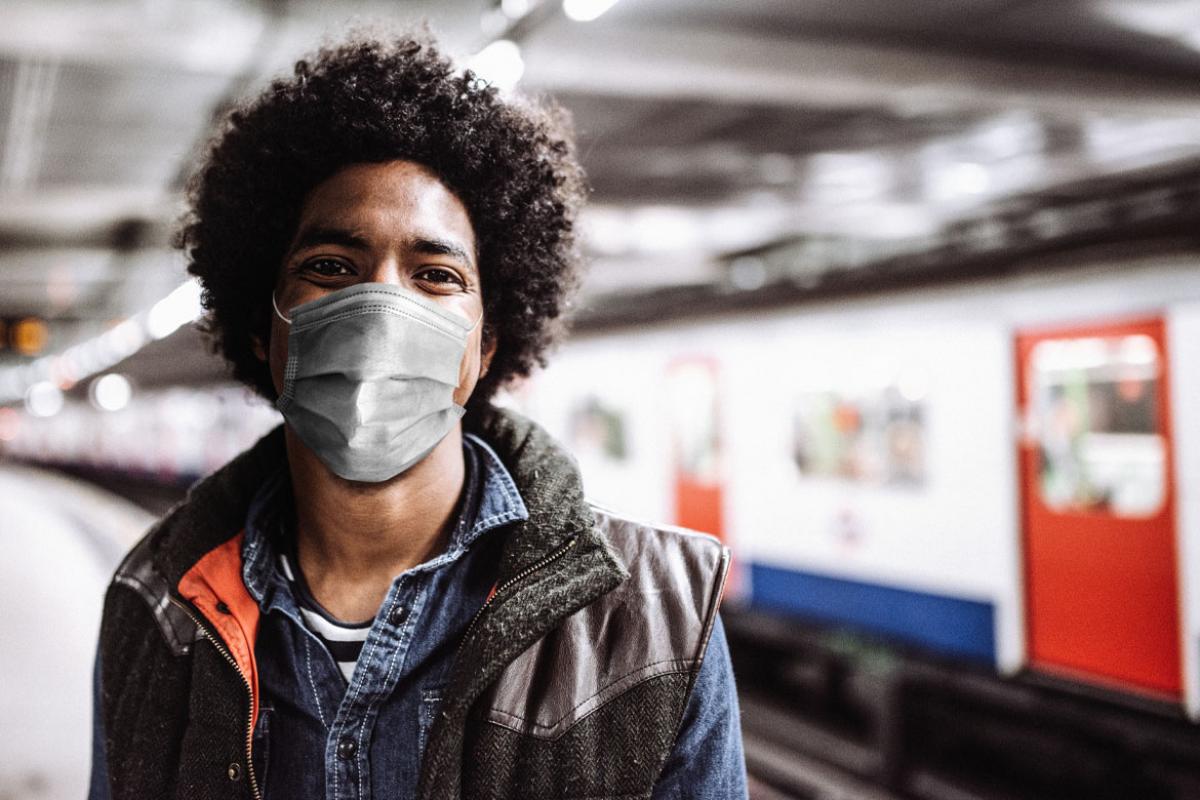 Person wearing a face mask in a train station