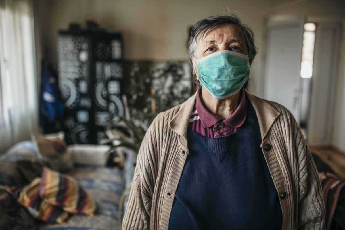 Person wearing a face mask standing in a living room
