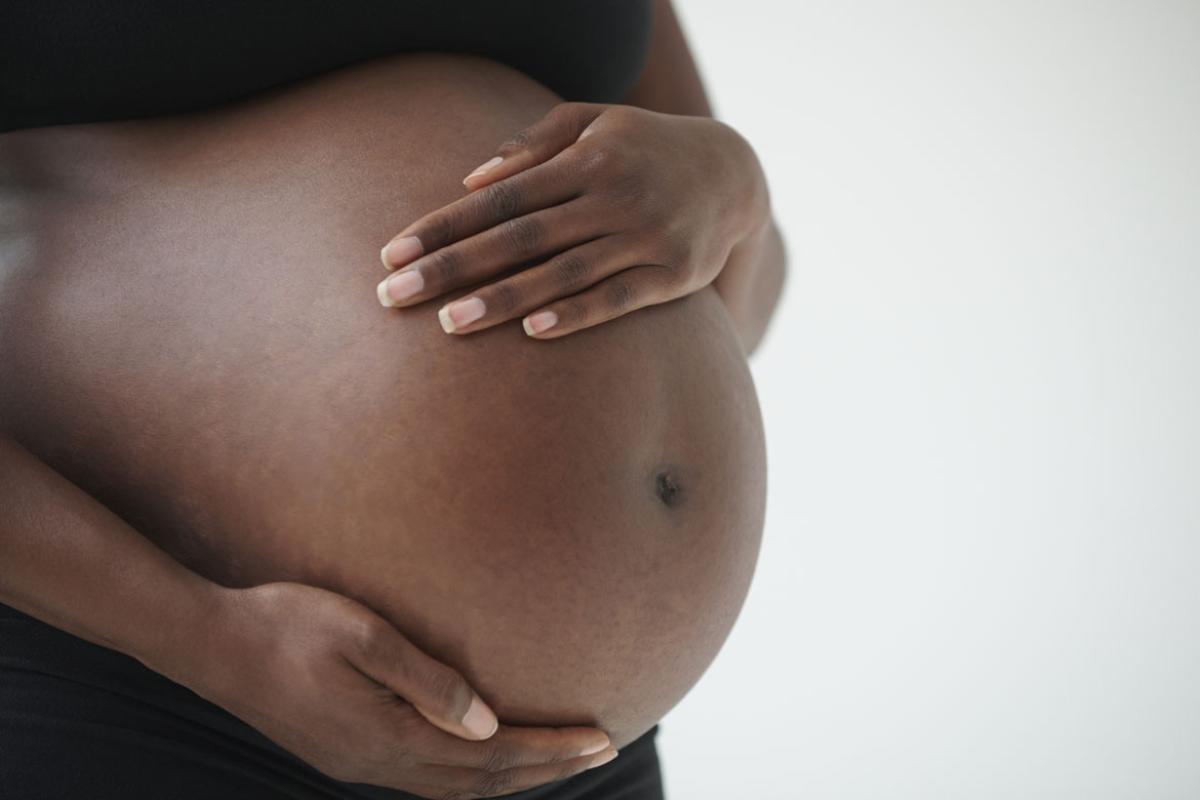 Pregnant woman holding hands on belly
