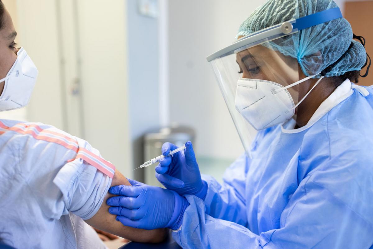 Health care worker administering vaccine