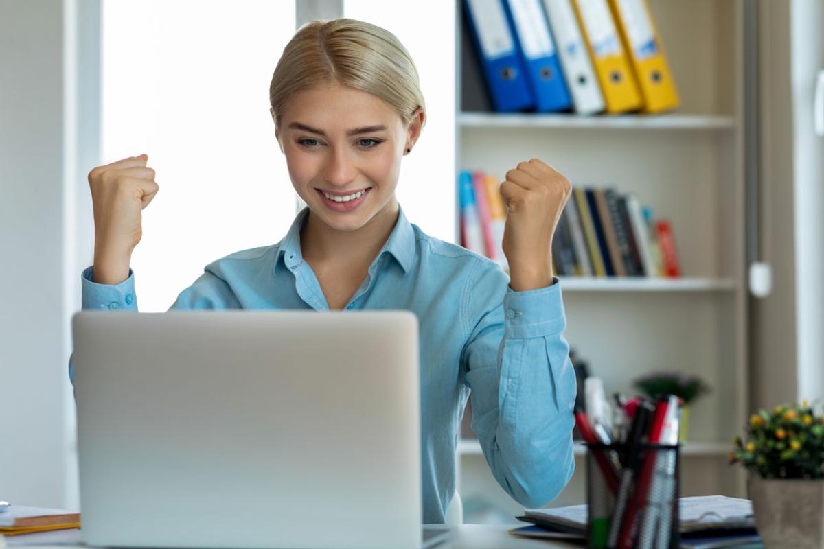 Smiling person looking at a laptop