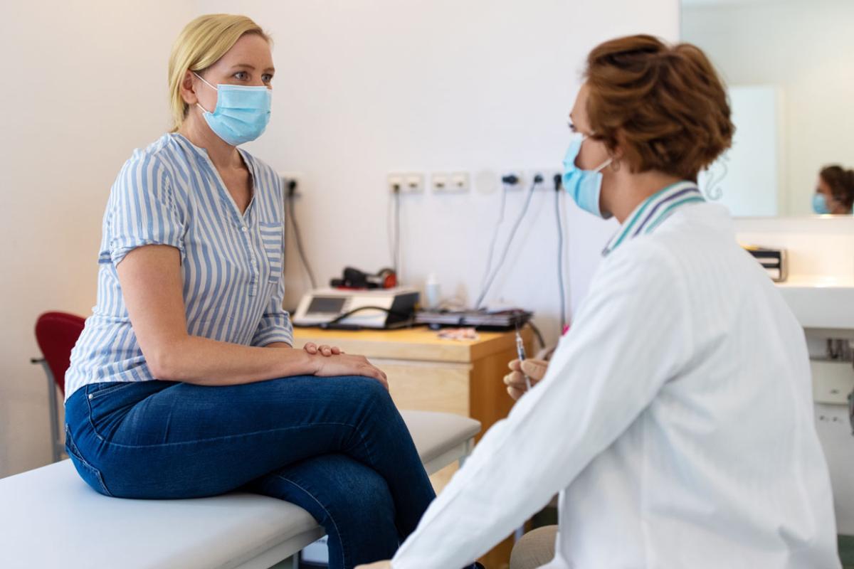 Patient with a mask being examined by physician