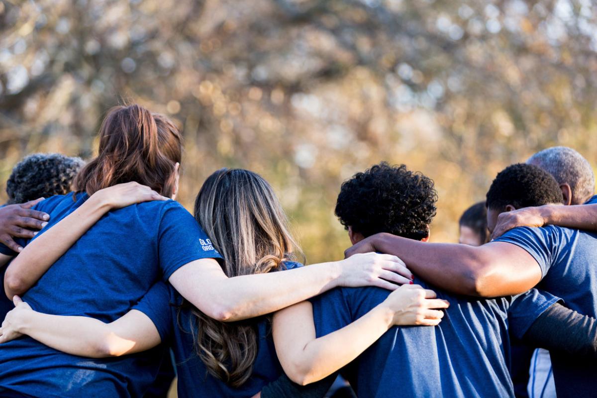 Group of people with arms over shoulders