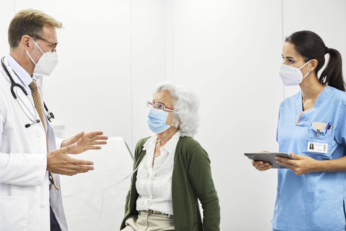 Health care workers speaking with patient
