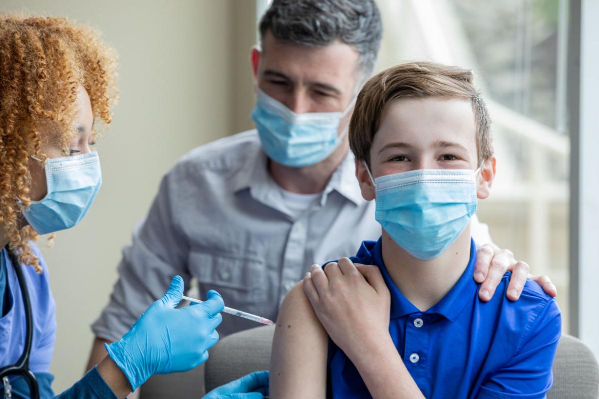 Physician giving child vaccine shot