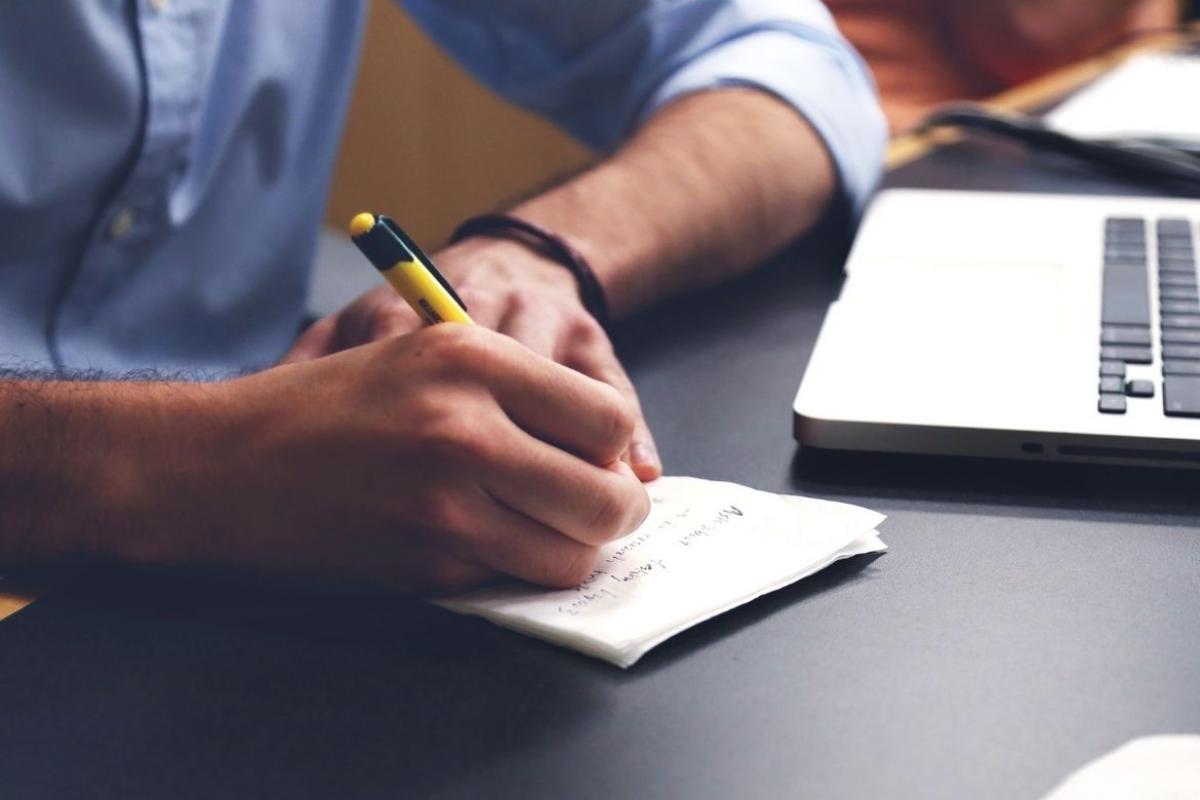 Hand writing on a pad of paper