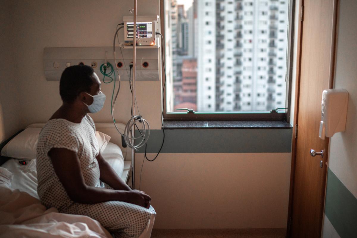 Person sitting in a hospital room, looking out the window