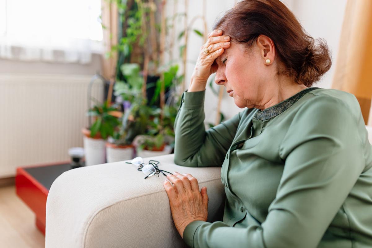 Person sitting on a couch with head in hand