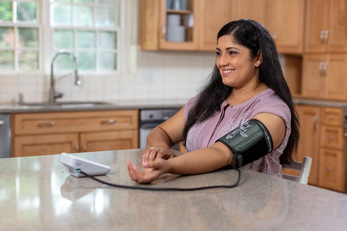 Smiling person measuring blood pressure