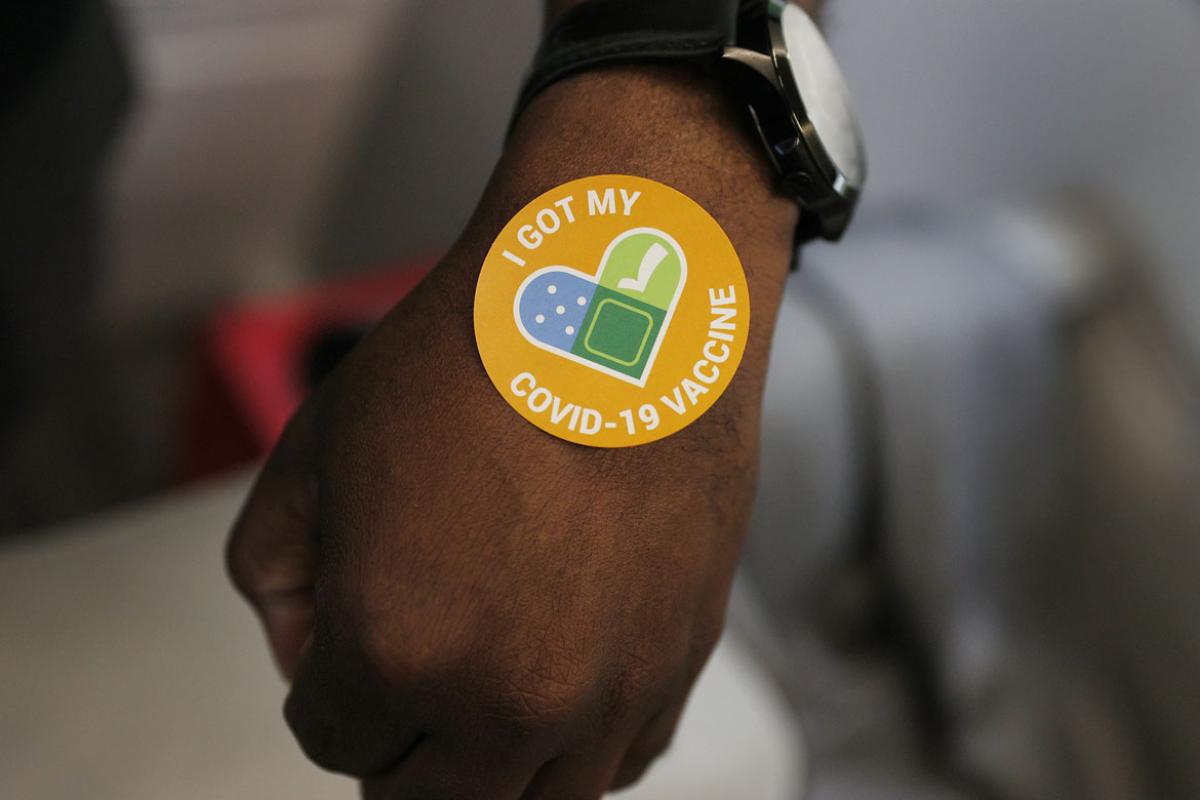 Hand with a sticker saying that they received a vaccine
