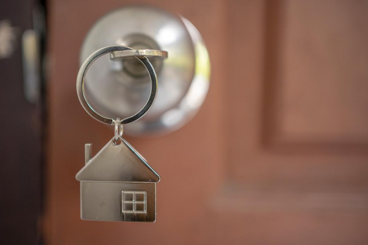 Door knob with key in the shape of a house
