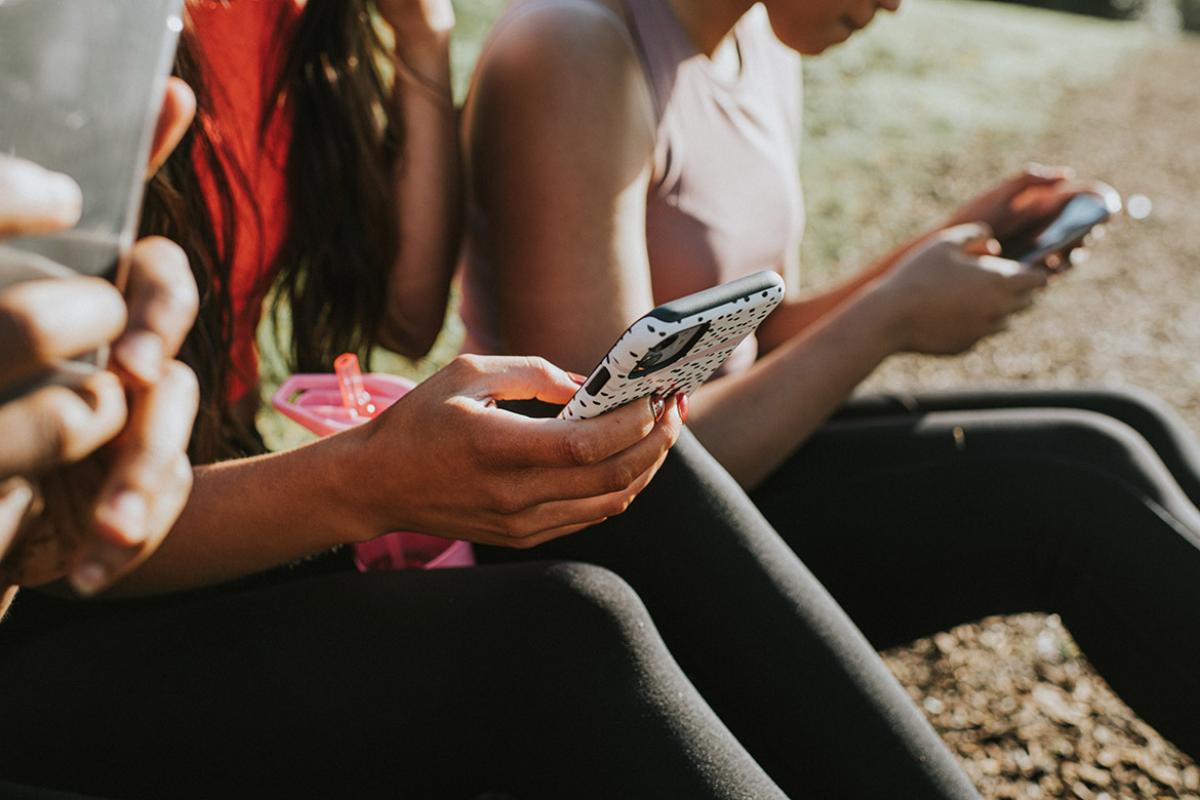 Tight shot of group of young people checking their cell phone screens