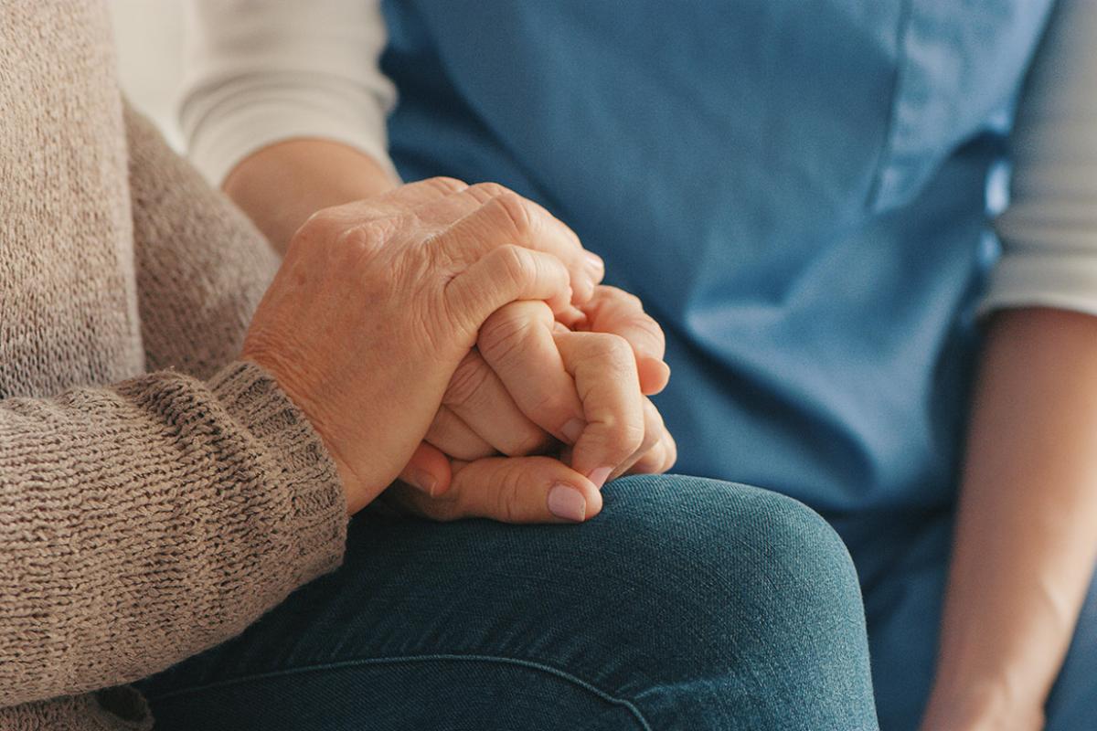 Tight shot of two people holding hands