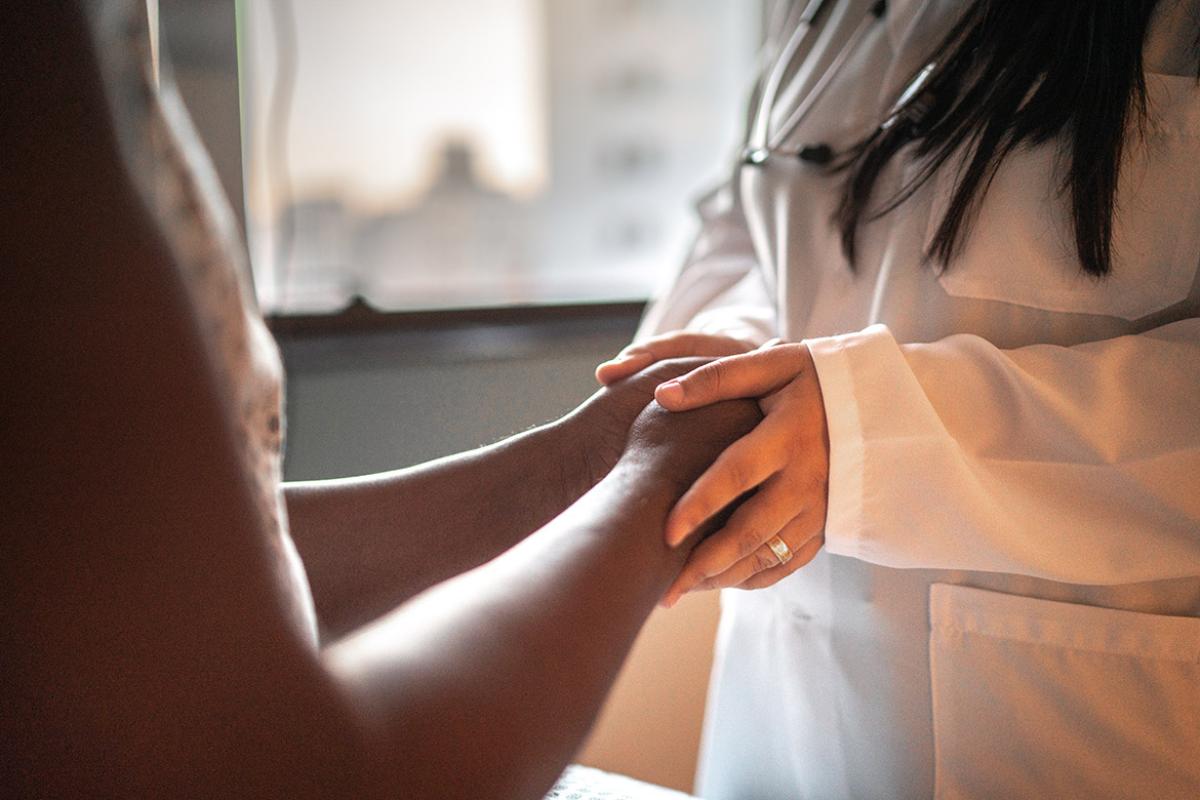 Close up of physician holding a patient's hands