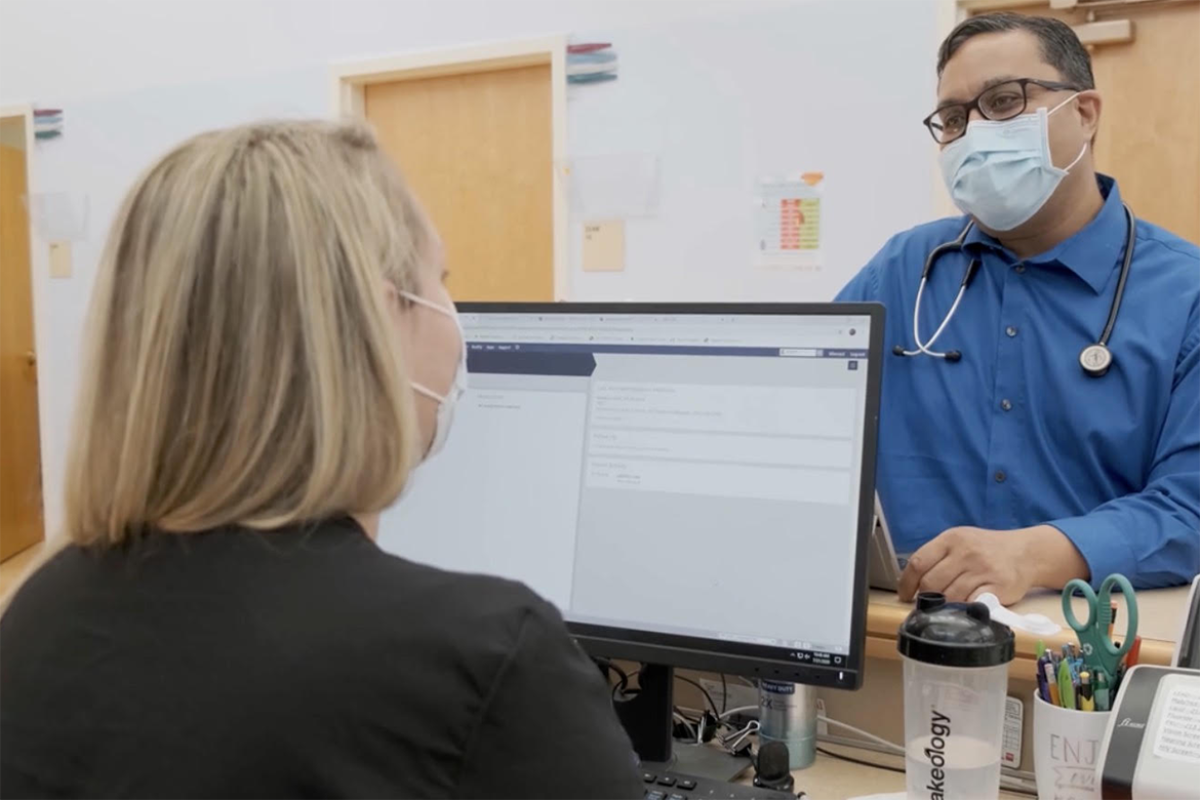 Leon Weaver, MD, reviews patient information between appointments