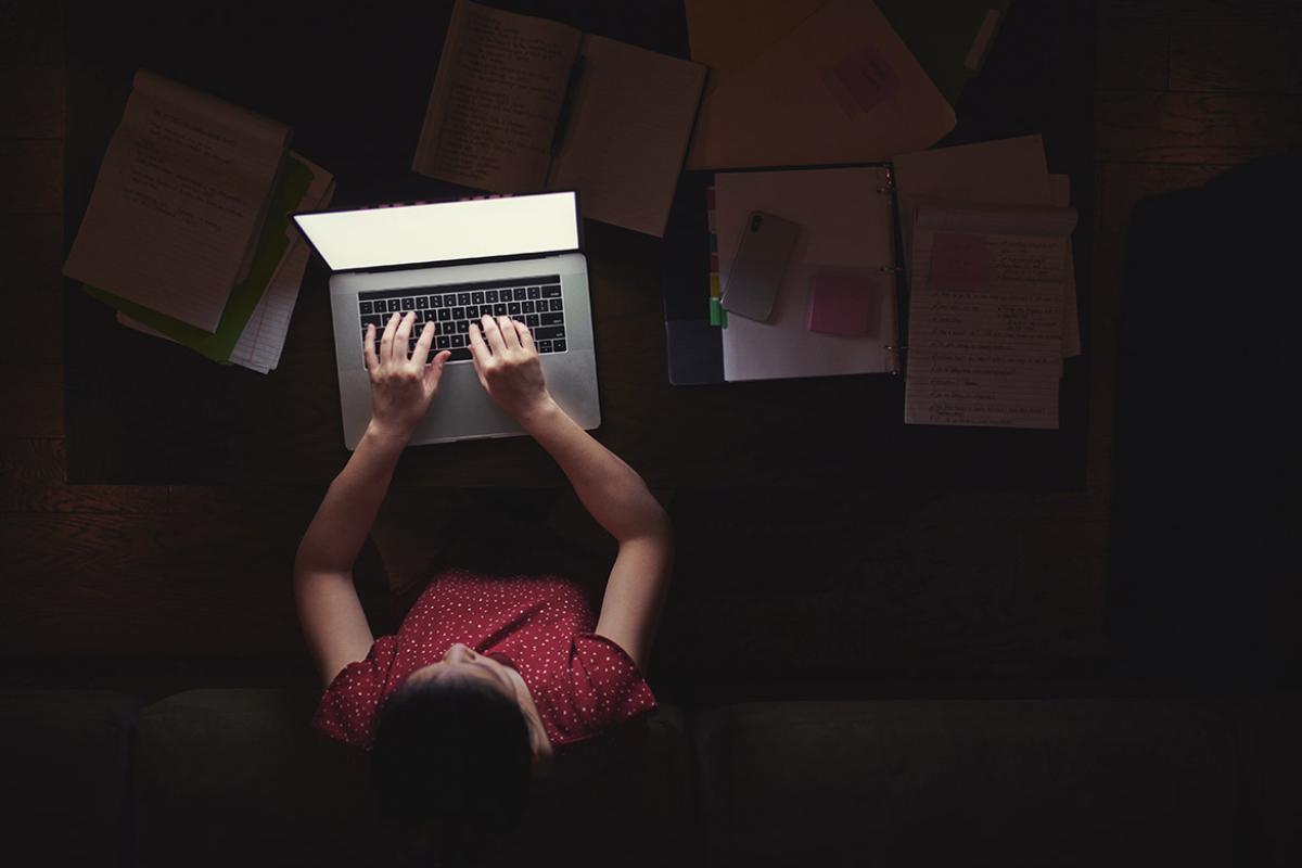 Person working on a laptop in a dark room