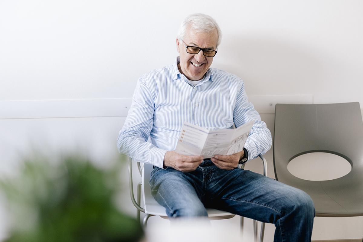 Smiling person reading a brochure